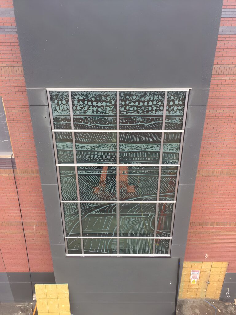 Vertical curtain wall glazing panel in a brick facade
