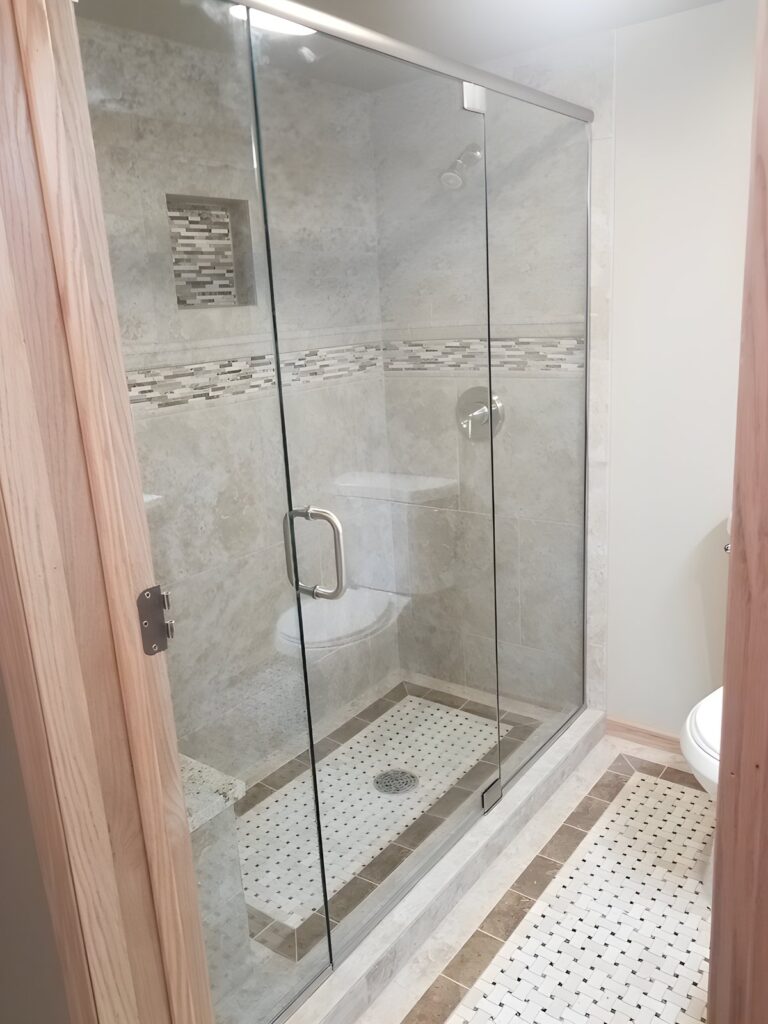 Frameless glass shower with tile accent